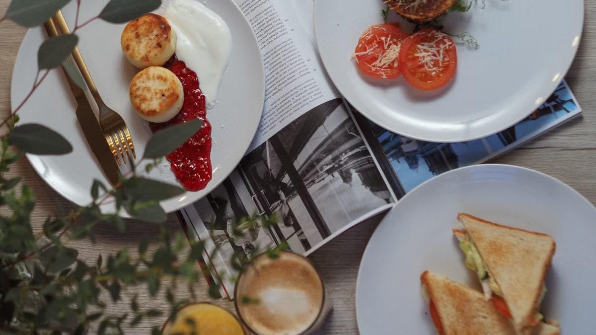 Overhead view of a stylish breakfast setup with toast, pastries, and beverages.